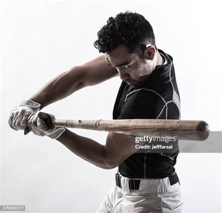 a man holding a baseball bat on top of a field