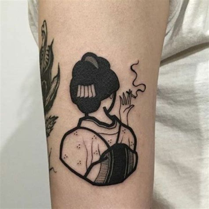 a person with a tattoo on their arm holding onto another persons hand