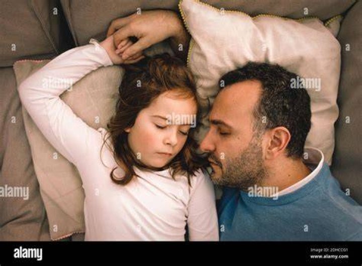 Father and daughter sleeping on couch Stock Photo Dissolve