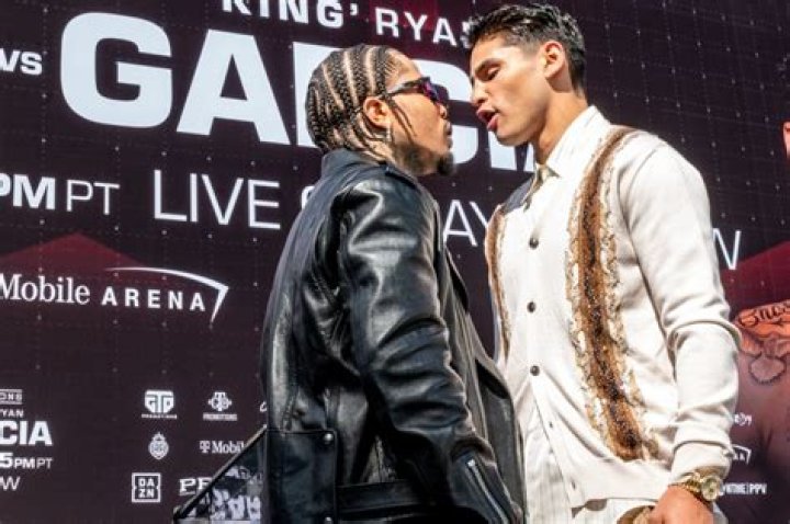 Ryan Garcia covers up his tattooed torso and punches the air as he