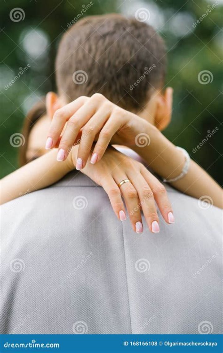 The Bride Hands Her Husband a Hug Around the Neck Close Up. Wedding