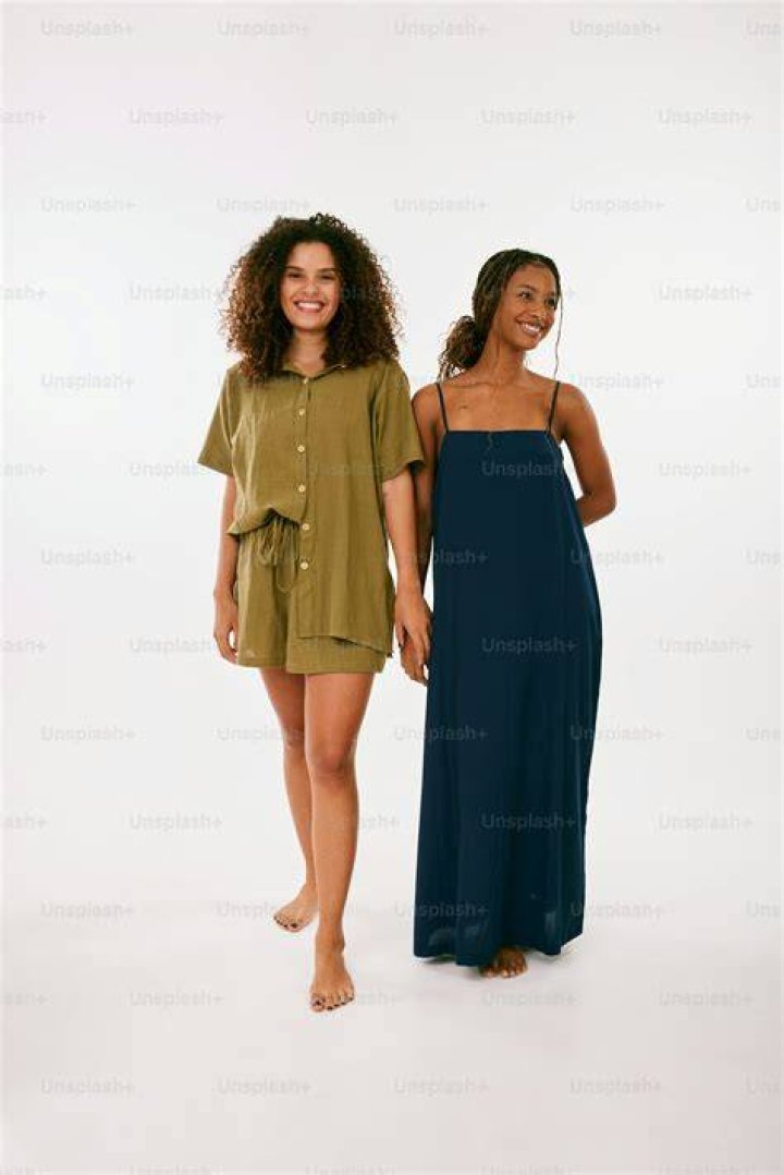 two women standing next to each other in front of a red carpet with an